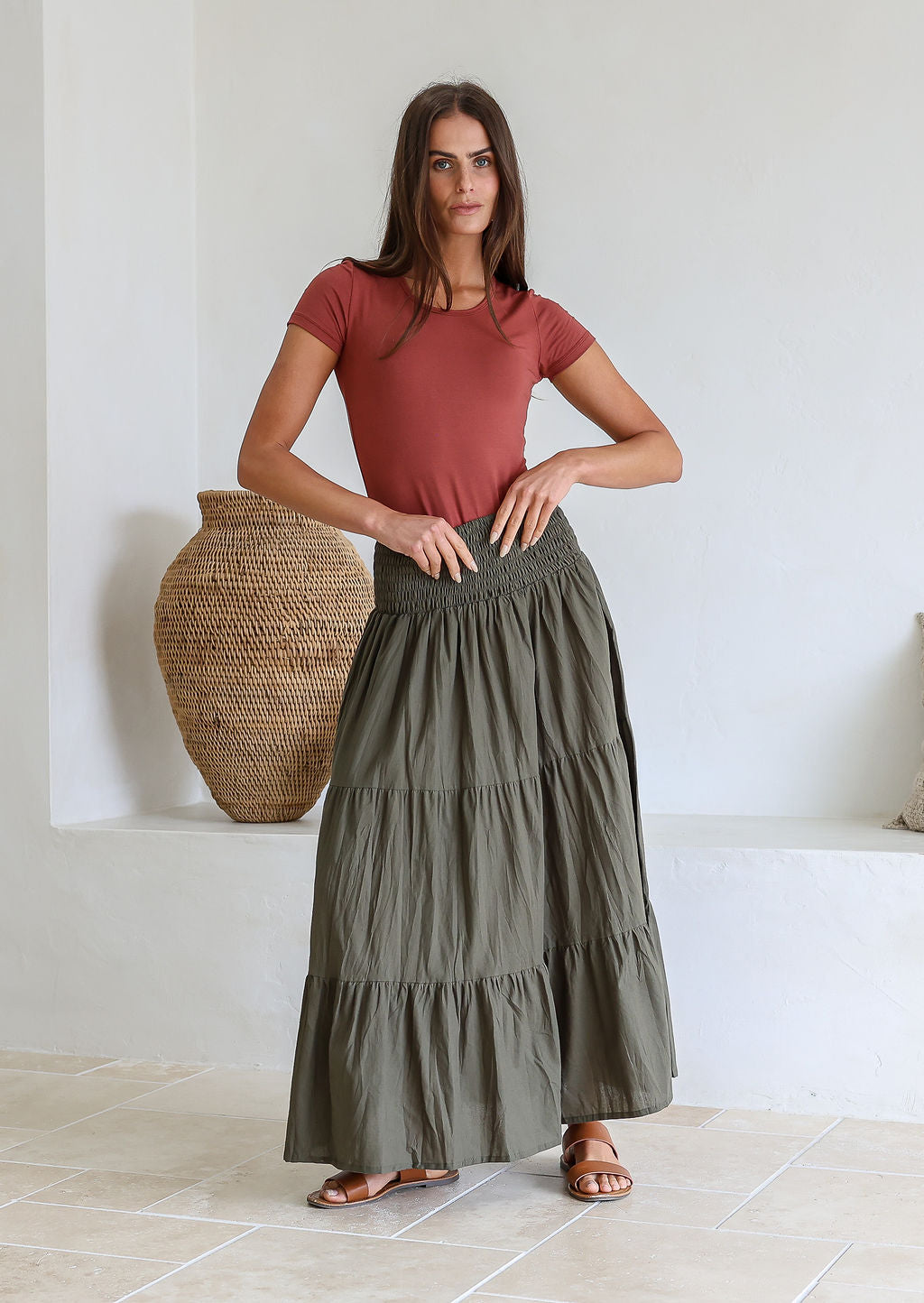 woman wearing a simple pink top and 100% cotton maxi skirt in olive green shade.