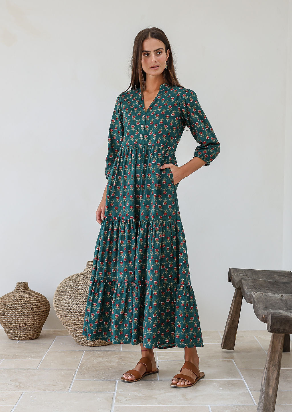 Woman wearing relaxed fit floral printed cotton maxi dress in green with 3/4 sleeves, pockets and three tiered skirt