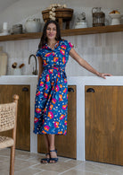Model wearing a 100% cotton shirt style dress in navy based floral print with removable waist tie and pockets