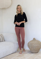 Woman wearing a leggings high waisted full length soft rayon in dusty pink