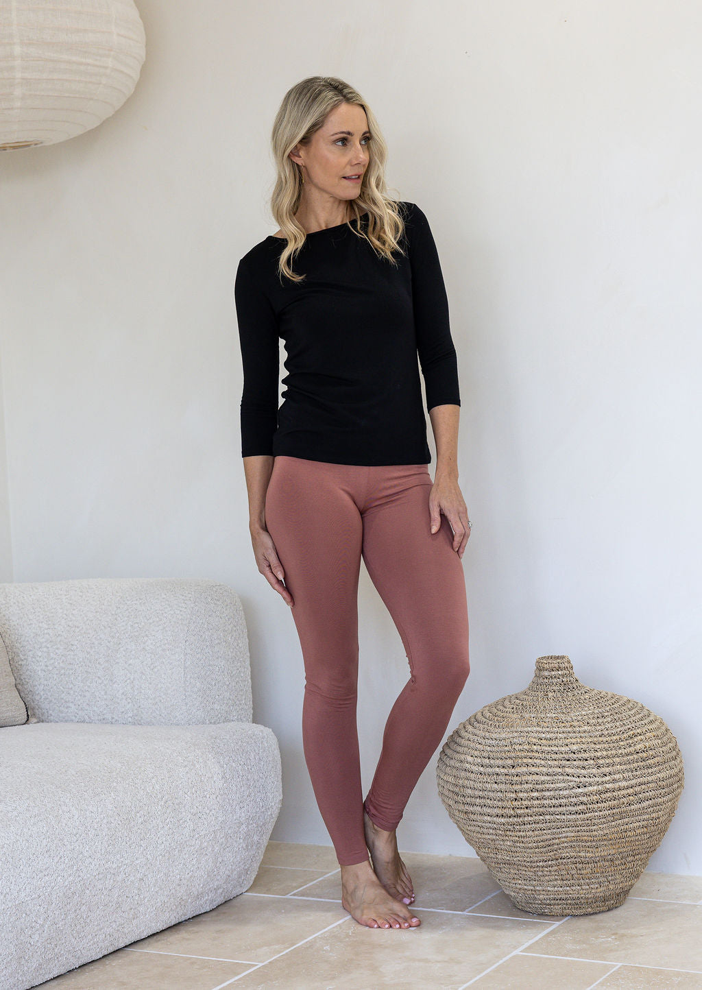 Woman poses in a high waisted full length leggings soft rayon in dusty pink