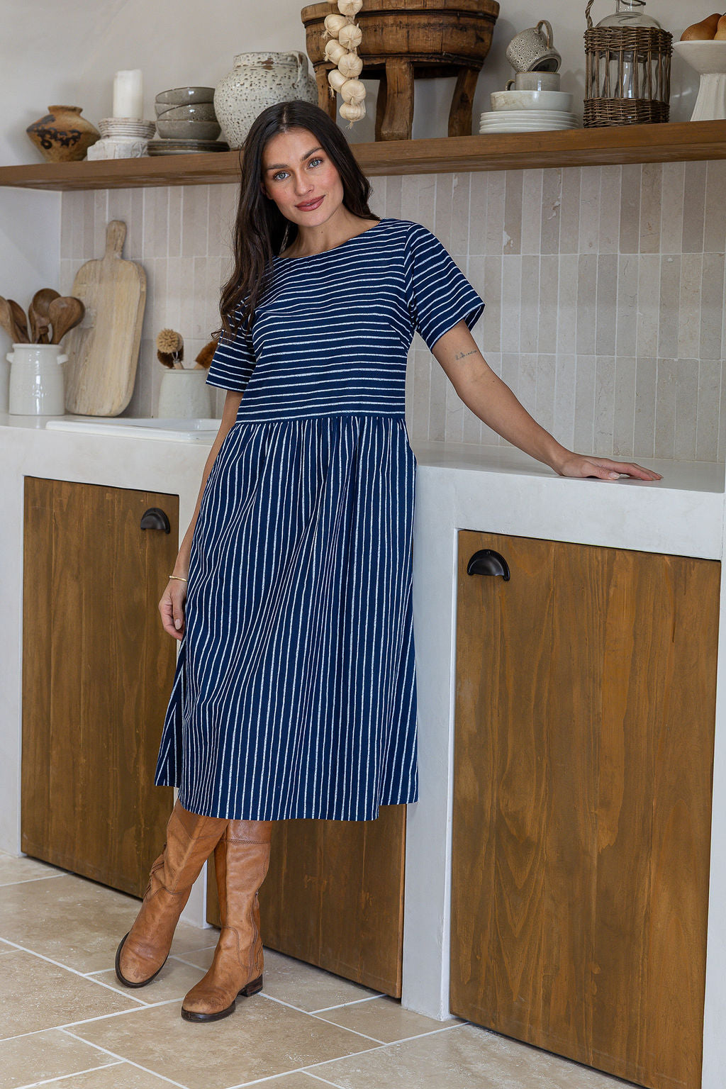 Woman wearing a 100% cotton relaxed fit dress with round neckline and pockets