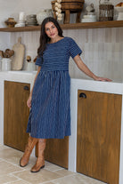 Woman wearing a 100% cotton relaxed fit dress with round neckline and pockets