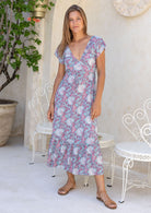 Model wearing 100 percent rayon maxi dress with elasticised cross-over bodice and tier at the bottom of the dress.