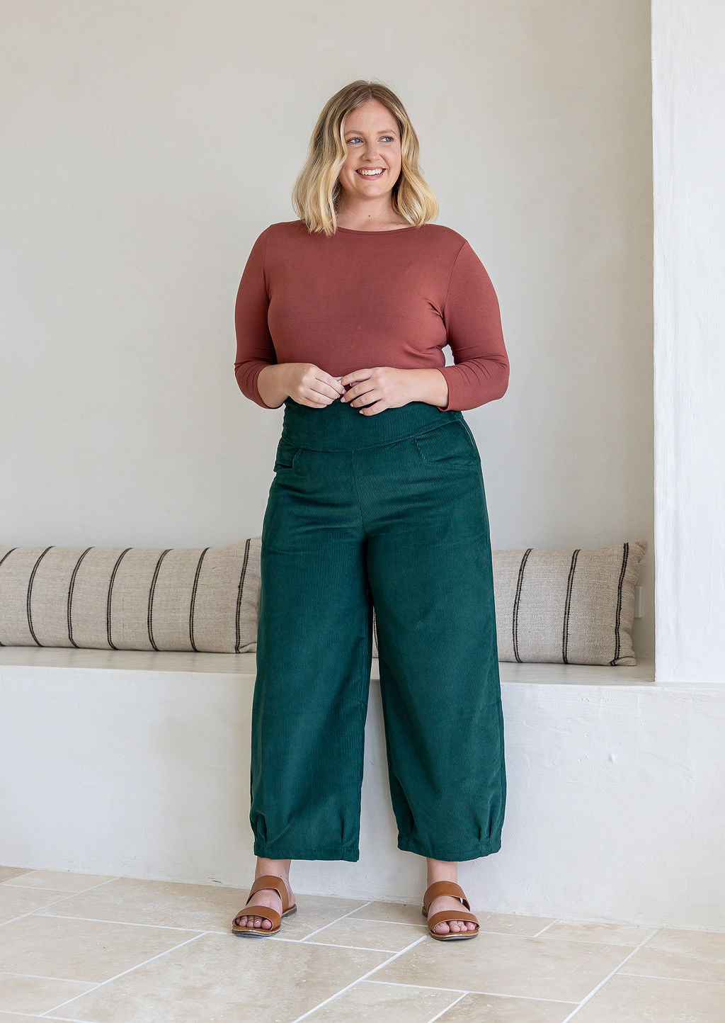 Woman wearing a cotton corduroy wide-leg dark green pants. 