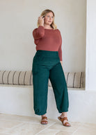 Model wears corduroy wide leg pants with side zipper, pockets and small pleats at ankles.