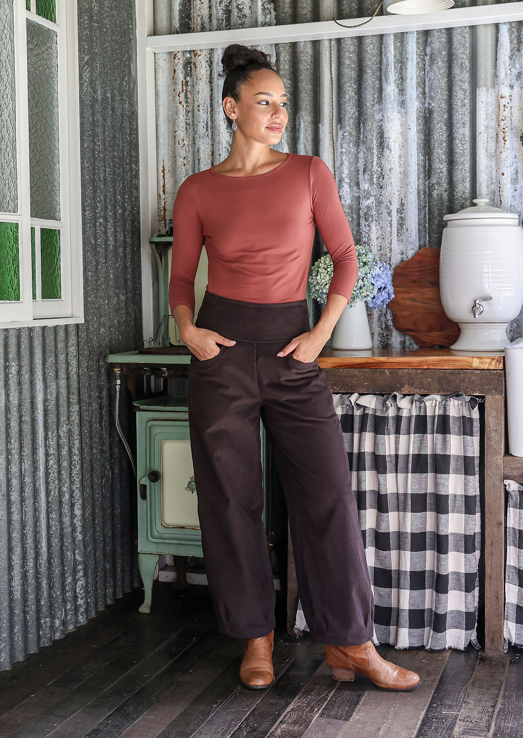Woman posing in cotton corduroy wide-leg dark brown pants with hand in pockets