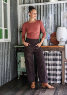 Woman posing in cotton corduroy wide-leg dark brown pants with hand in pockets