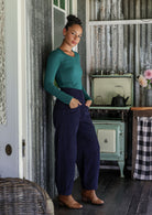 Woman standing sideways wearing cotton corduroy wide leg pants in navy blue, paired with basic rayon top 