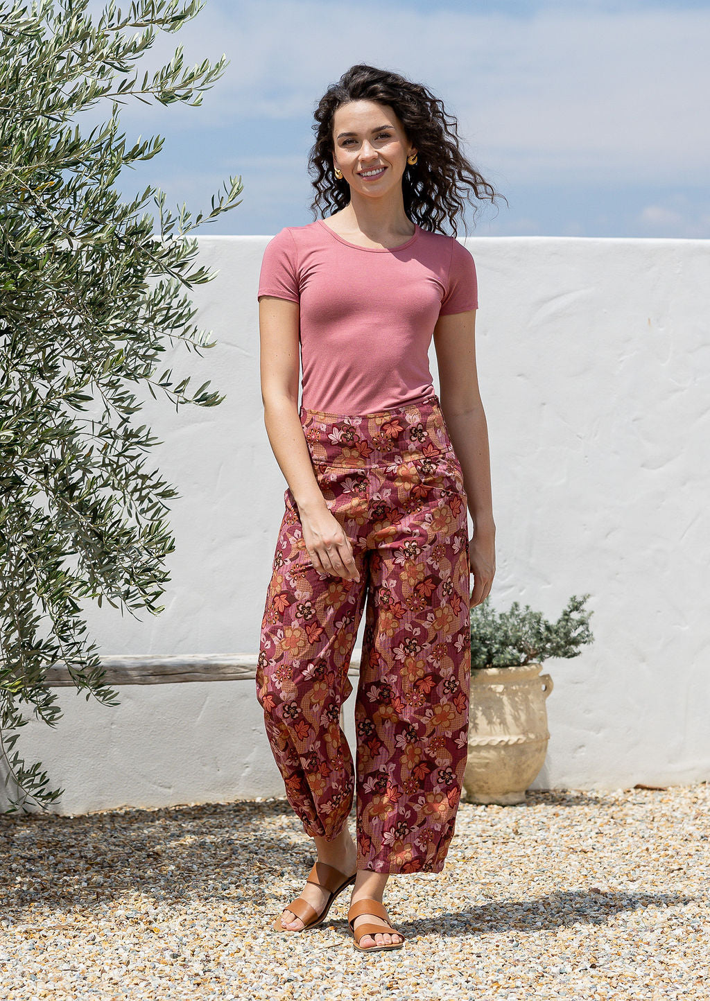 Model posing in a , 100 percent cotton wide leg pants with pleated ankles, pockets and side zipper