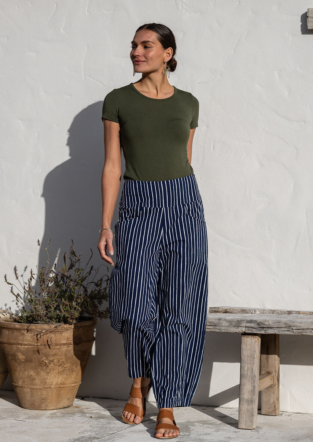 Woman wearing cotton wide leg pants in navy based white striped print with pockets paired with basic top 