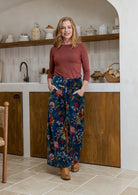 Woman wearing a 100% cotton velvet floral pants with wide waistband and a side zip