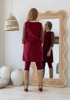 Woman standing backwards wearing cotton corduroy tunic in cabernet 