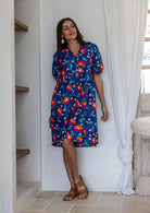 Woman wearing a knee length relaxed fit button through 100% cotton dress with elbow length sleeves