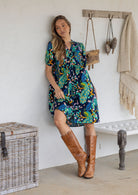 Woman wearing a knee length relaxed fit button through 100% cotton dress