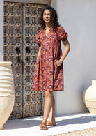 Woman wearing a knee length relaxed fit button through 100% cotton dress with elbow length sleeves