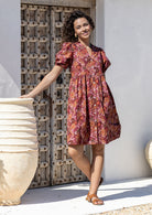 Woman wearing a warm toned Japanese style print dress with pink, maroon, brown, peach and khaki palette. 