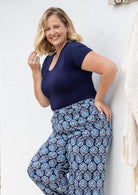 Woman wearing a scoop neck navy blue rayon fitted t-shirt standing against a white wall