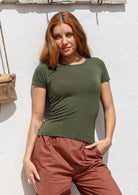 Woman is wearing a 100% rayon fitted scoop round neck short sleeve double stitch hem soft stretch in olive green. 