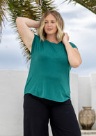 Woman wearing a soft flattering fit green rayon jersey t-shirt.