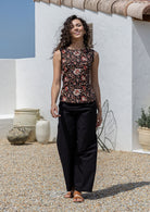 Model poses in a vintage style sleeveless cotton top with plain black trim around the arms and a side zipper 