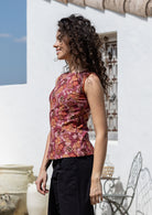 Model poses in a vintage style sleeveless cotton top with plain black trim around the arms and a side zipper 