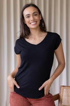 Woman wearing a black stretch rayon t-shirt with a V-neck and cap sleeves