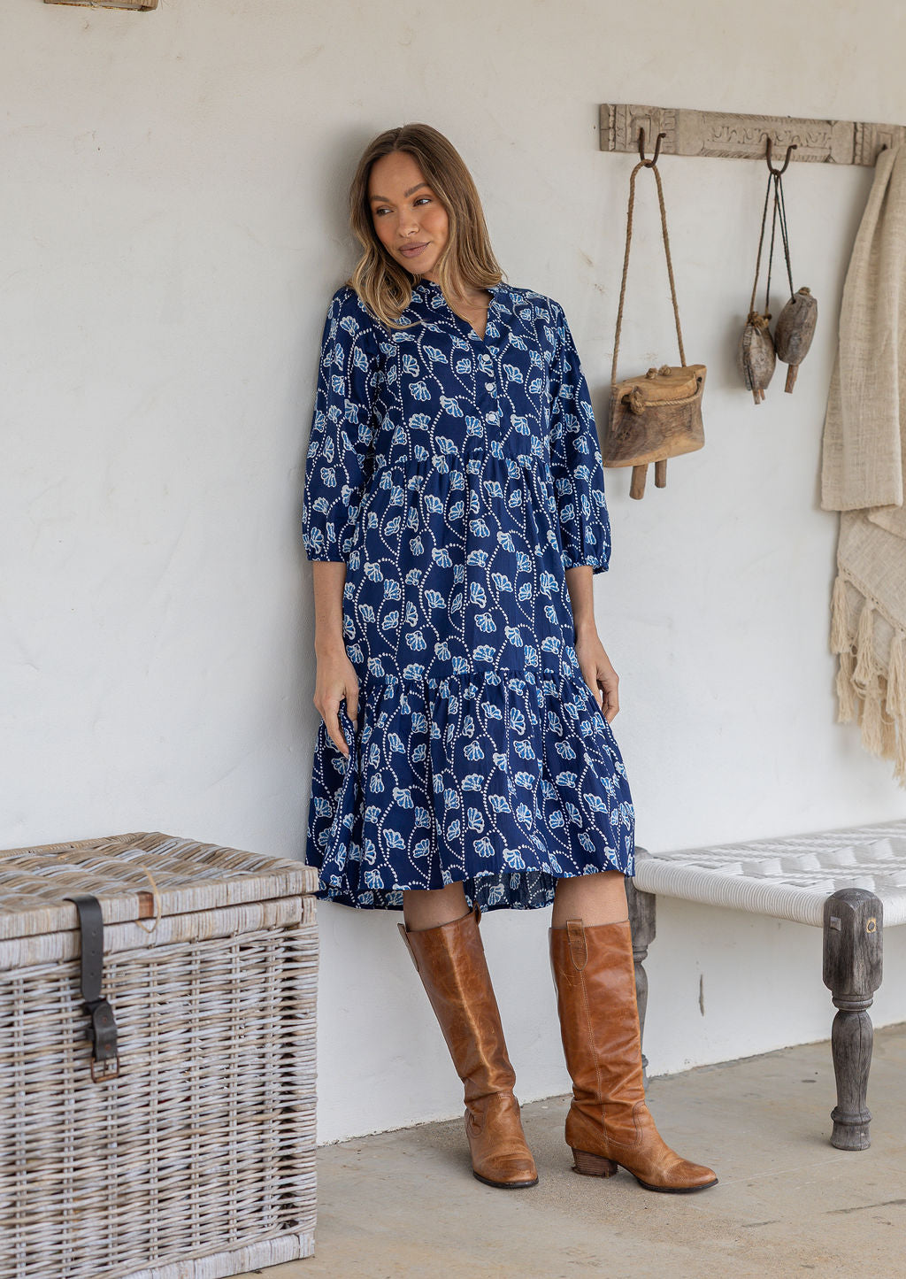 Woman poses in cotton tiered over the knee dress with 3/4 sleeves, buttoned bodice and V-neckline