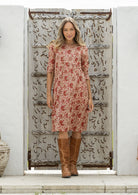 Woman wearing a 100% cotton floral dress with 3/4 sleeves and pockets 