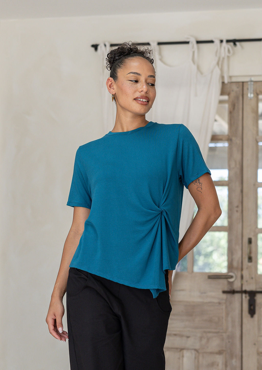 Woman wearing Twist-front teal rayon T-shirt for women, short-sleeve crew-neck top with soft draped knot detail