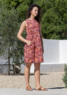 Woman in a Japanese style floral print sleeveless above knee dress with hand in pocket