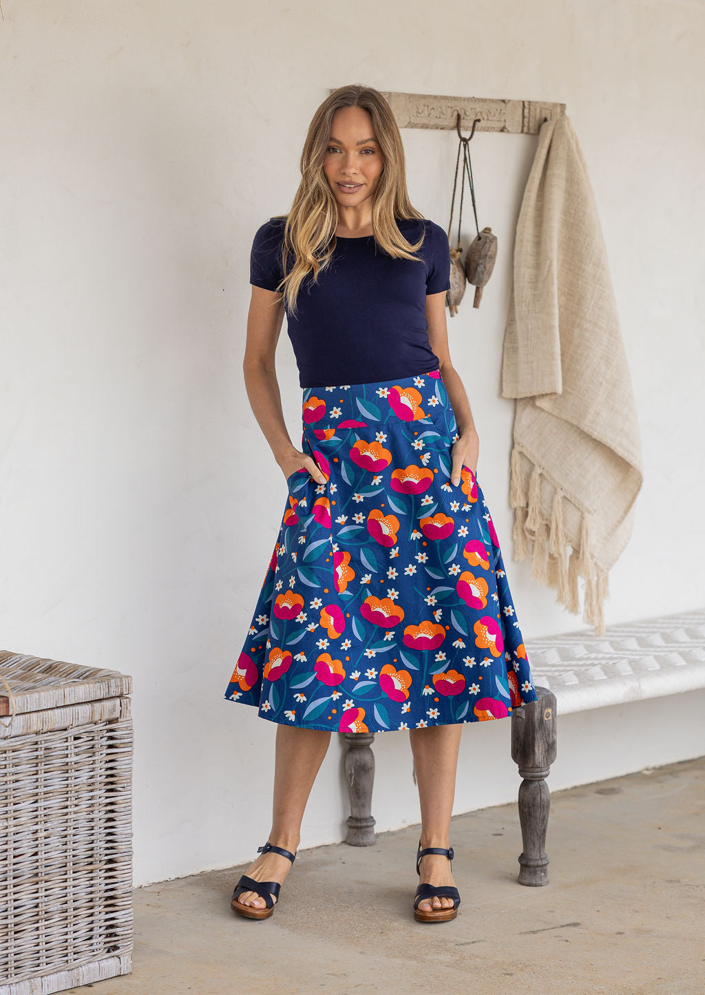 Model wearing 100% cotton knee length A-line skirt with side zipper and pockets in royal blue based floral print