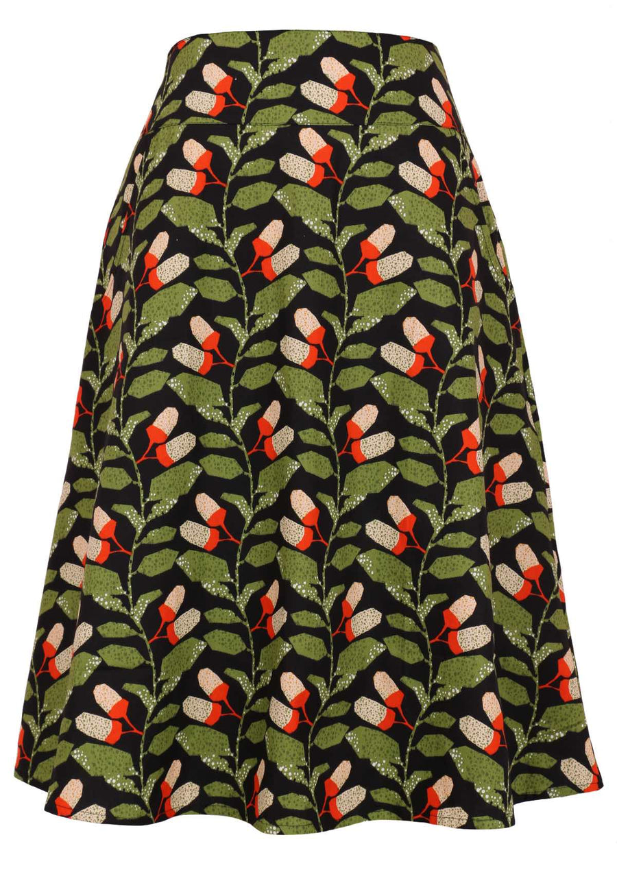 Model wears Zarah Skirt Oak green, orange and white speckled botanical print on a black base cotton, generous A-line skirt with wide yoke and pockets and a hidden side zip | Karma East Australia