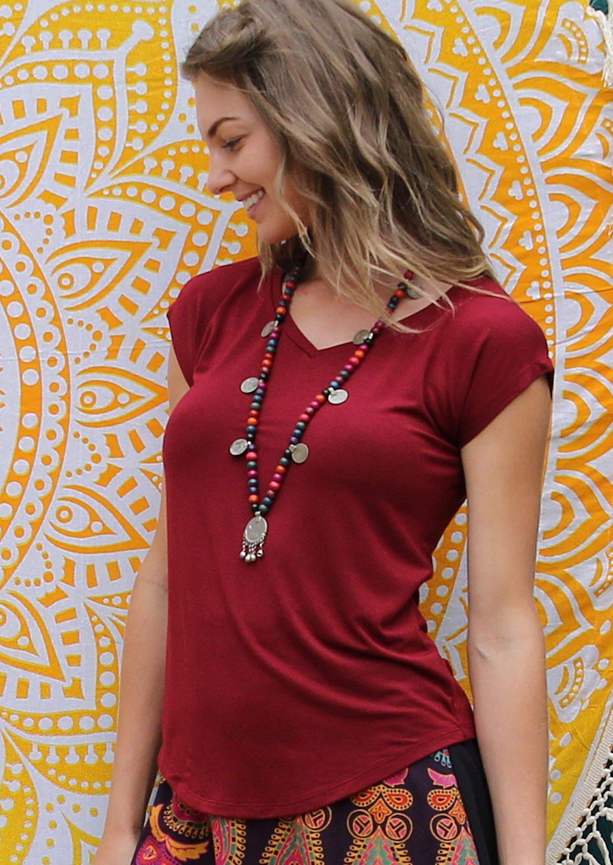 Woman wearing a maroon v-neck short cap sleeve rayon top