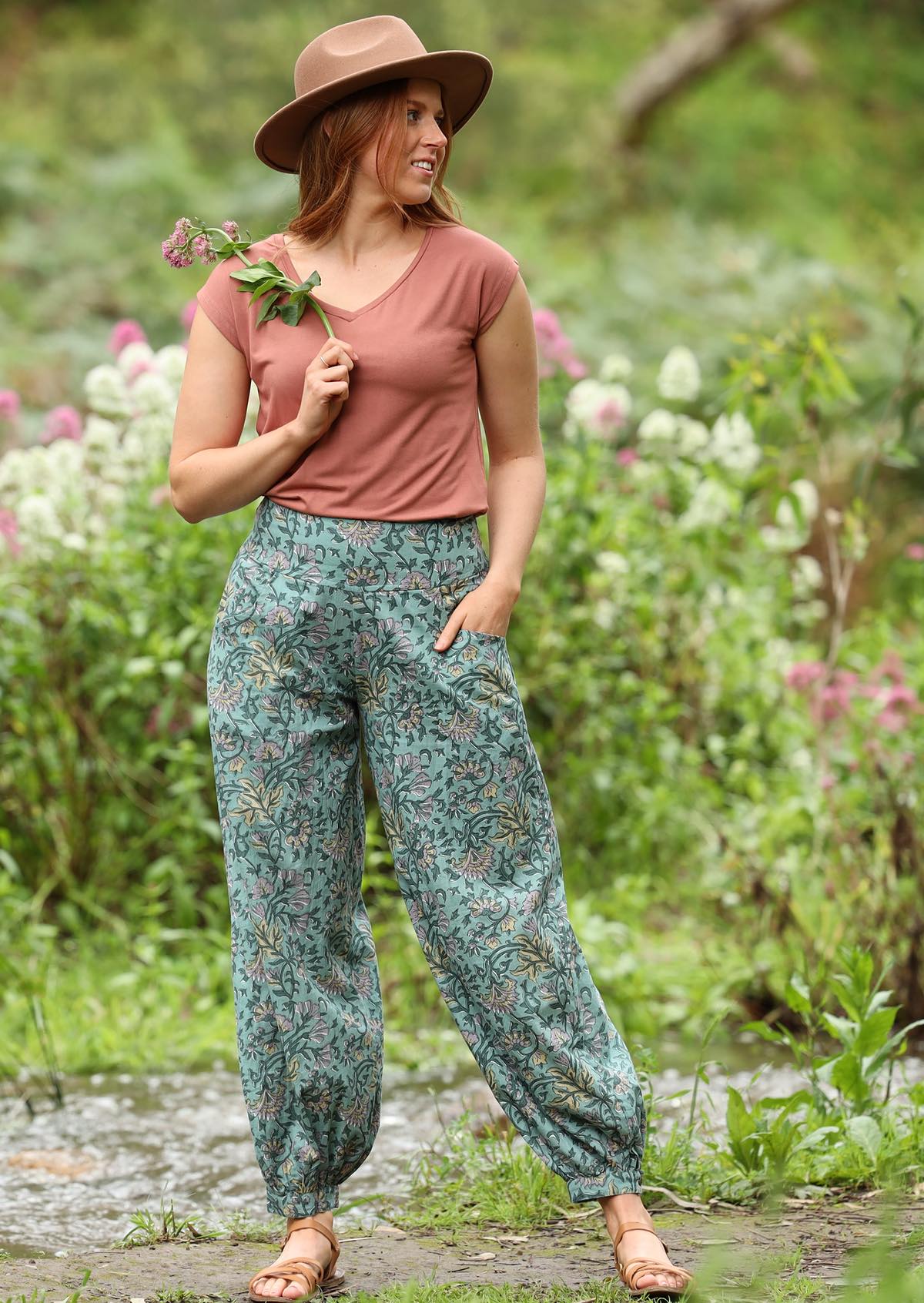 Acapulco Pants shirring across the back front wide flat waist band wide leg cuffed at ankle with button closure pockets 100% cotton light sage green background green and purple toned floral print | Karma East Australia