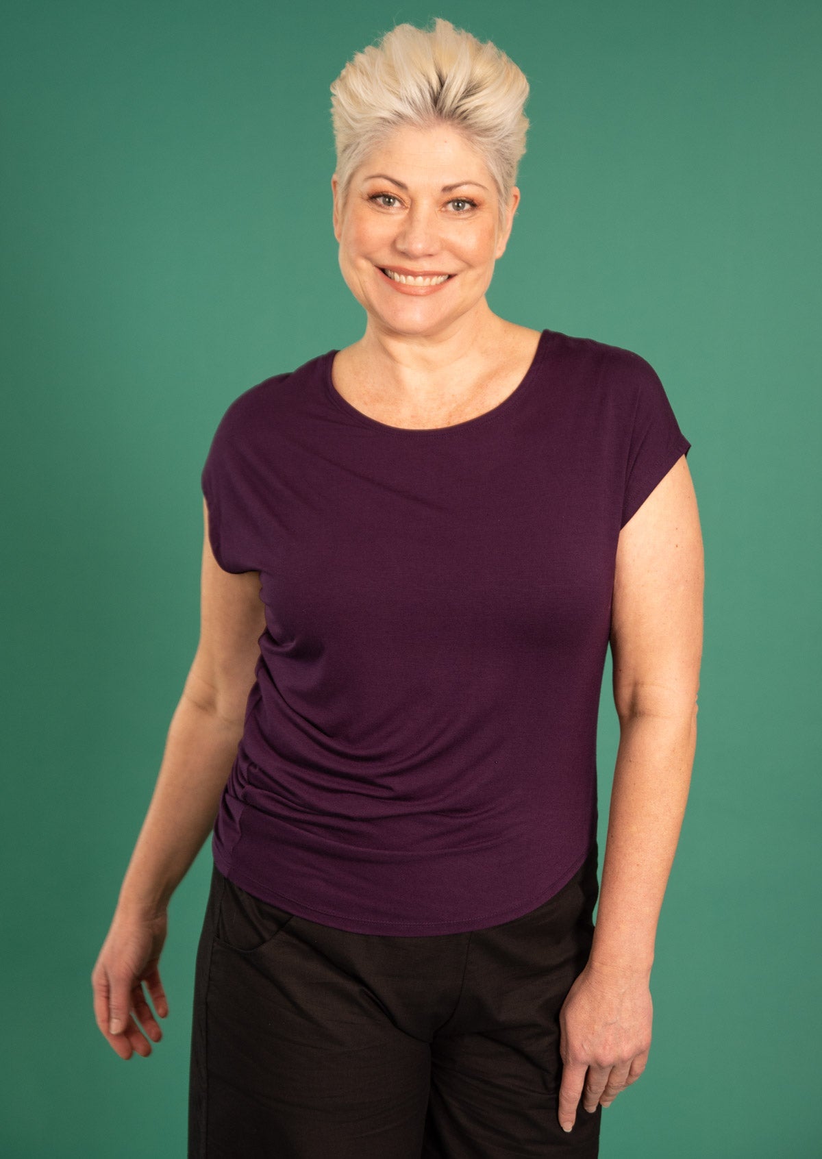 Woman wearing purple rayon t-shirt over black pants
