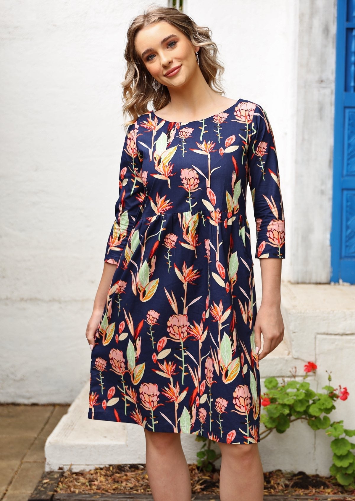 Women wears cotton dress with empire waistline with small gathers, wide round neckline and 3/4 sleeves