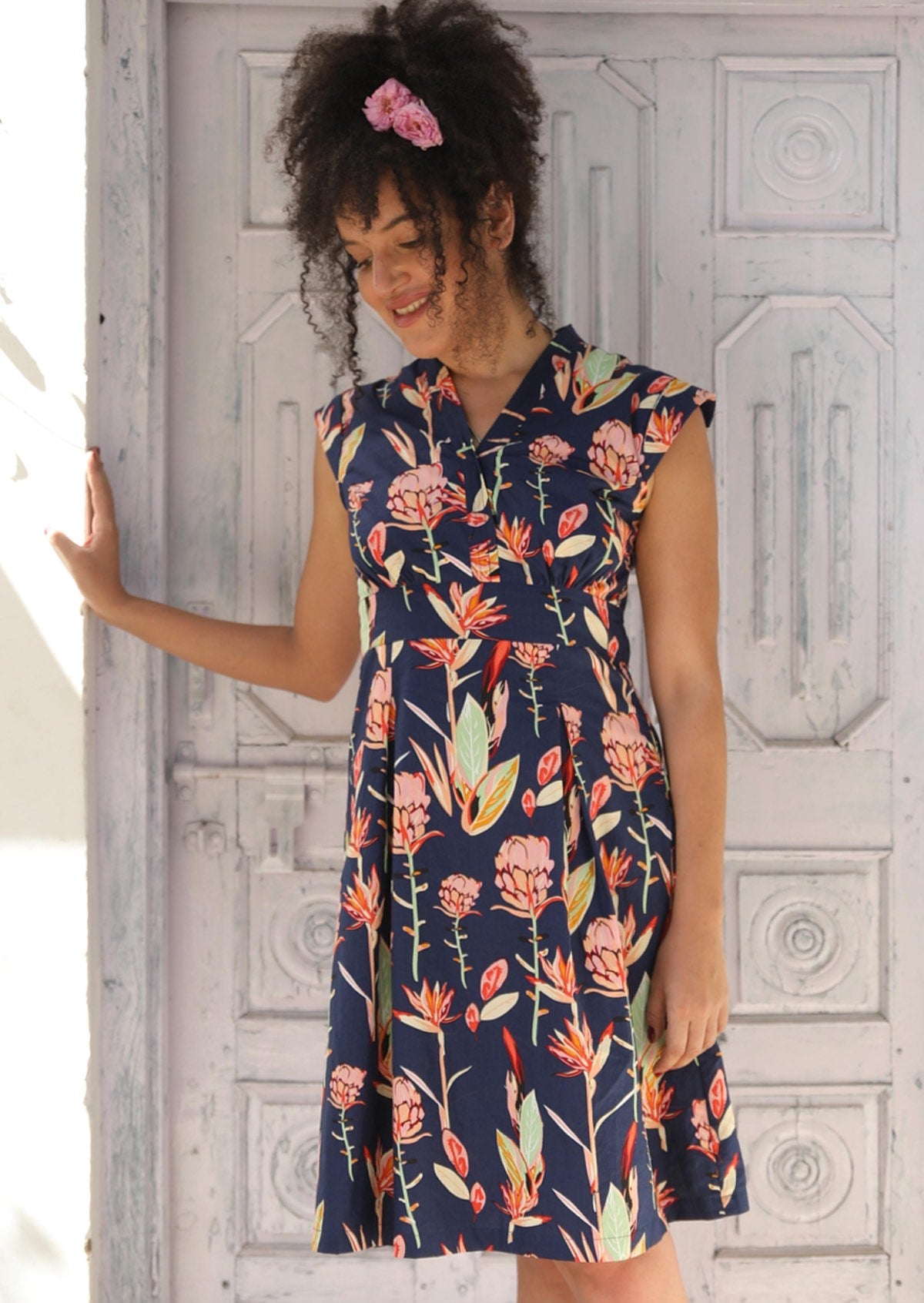 Woman wearing Floral V-neck Cotton Short Sleeve Dress, tailored bodice with cap sleeve empire waistline a-line skirt with box pleats