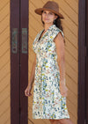 Woman wearing cream coloured cotton dress with floral print side view