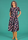 Woman wearing relaxed fit dress with round neckline, short sleeves and hidden pockets