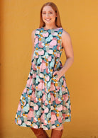 Model in 3 tiered high neck cotton dress with hands in pockets 