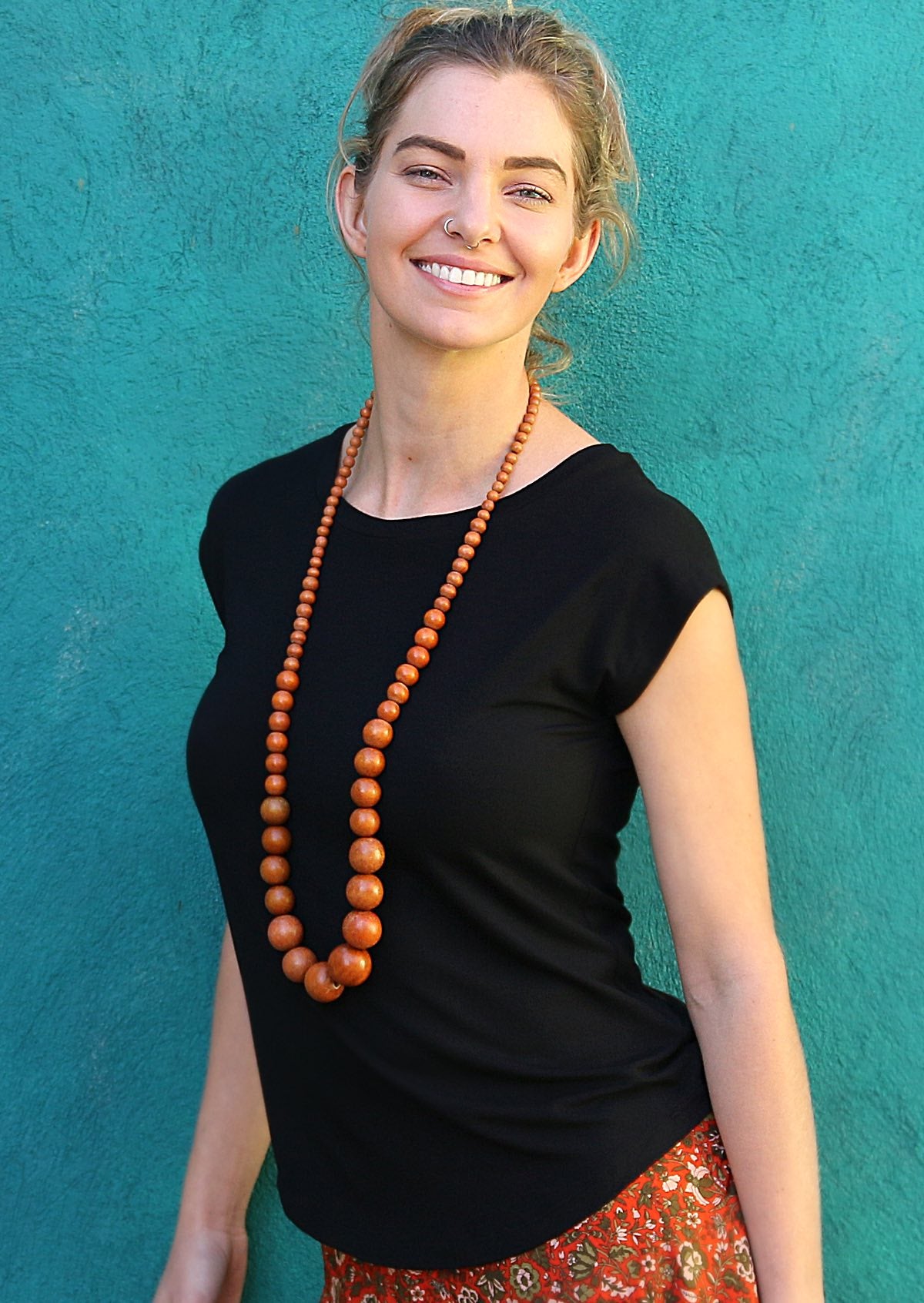 Woman wearing a soft flattering fit black rayon jersey t-shirt with red floral bottoms.