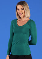 Woman with blonde hair wearing a jade green long sleeve stretch v-neck soft rayon top in front of blue background.
