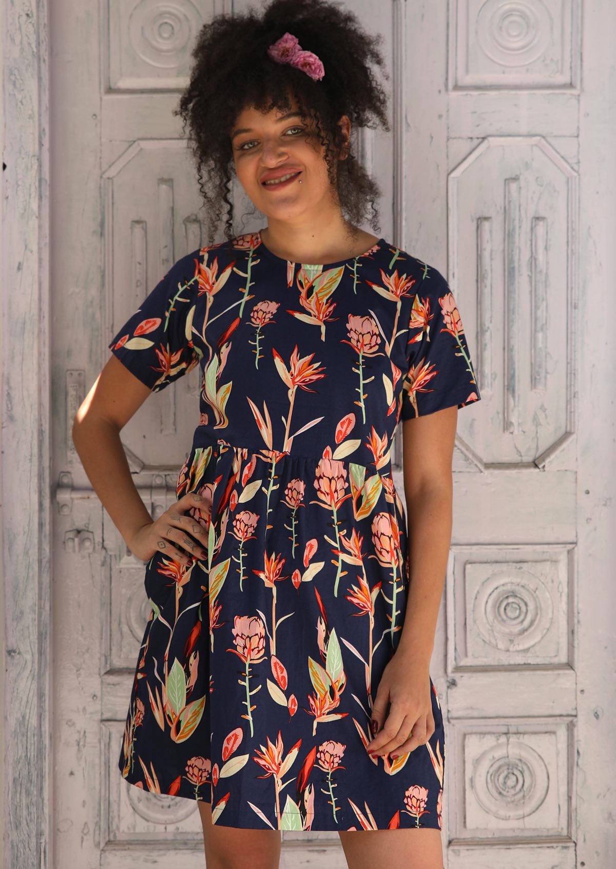 Woman in short sleeve relaxed fit Navy Floral Cotton dress cotton dress gathered pleats at waistline above knee length with pockets