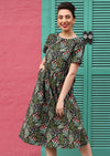 Maddison Dress cotton black background with green and peach floral print midi dress round neckline short sleeve gathered pleats at waist with pockets | Karma East Australia