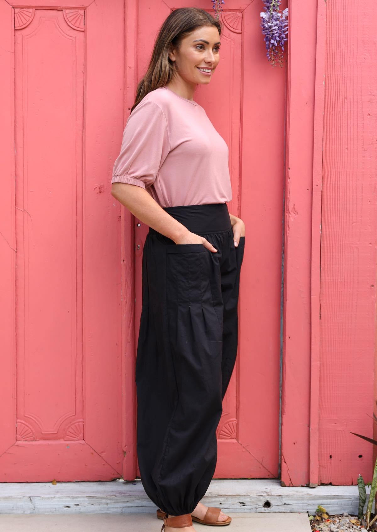 Woman wears black 100% cotton harem pants designed in Australia