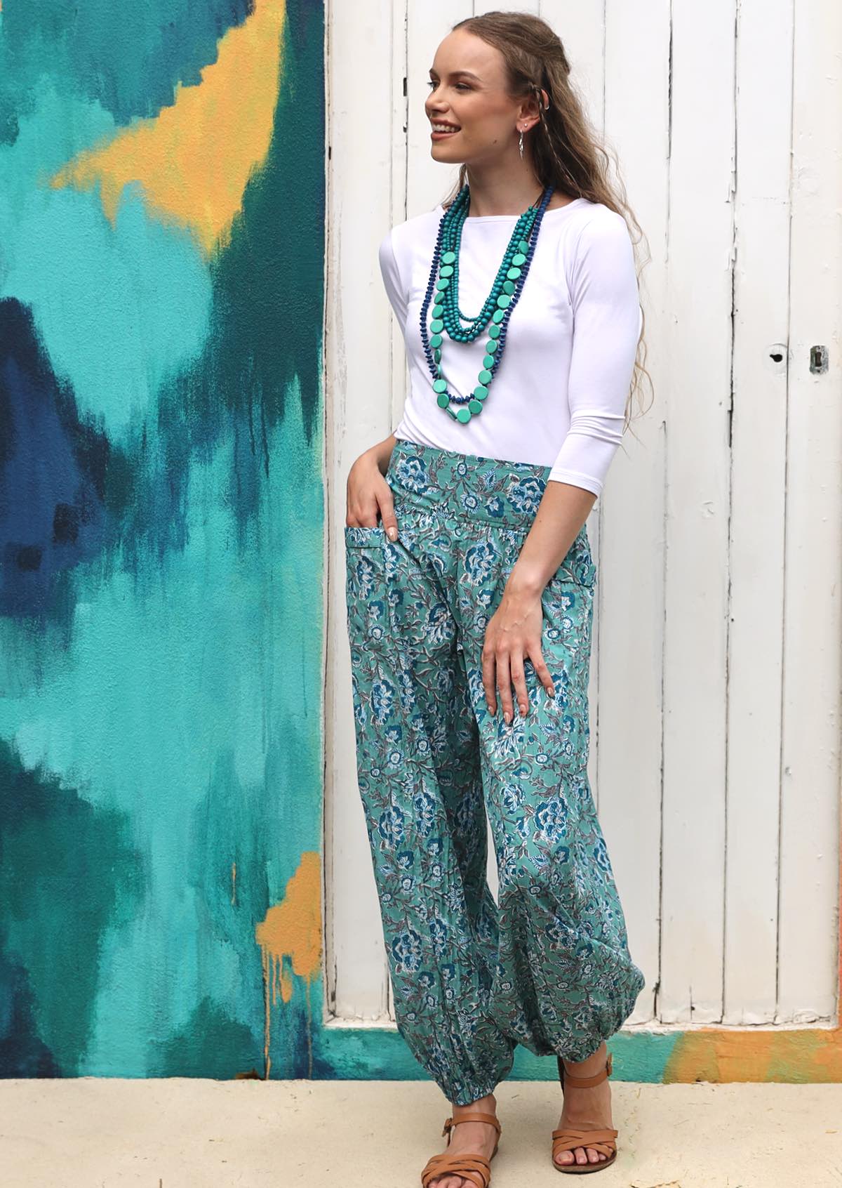 Model wears 100% cotton pants with wide elastic waistband and hand in deep pocket.