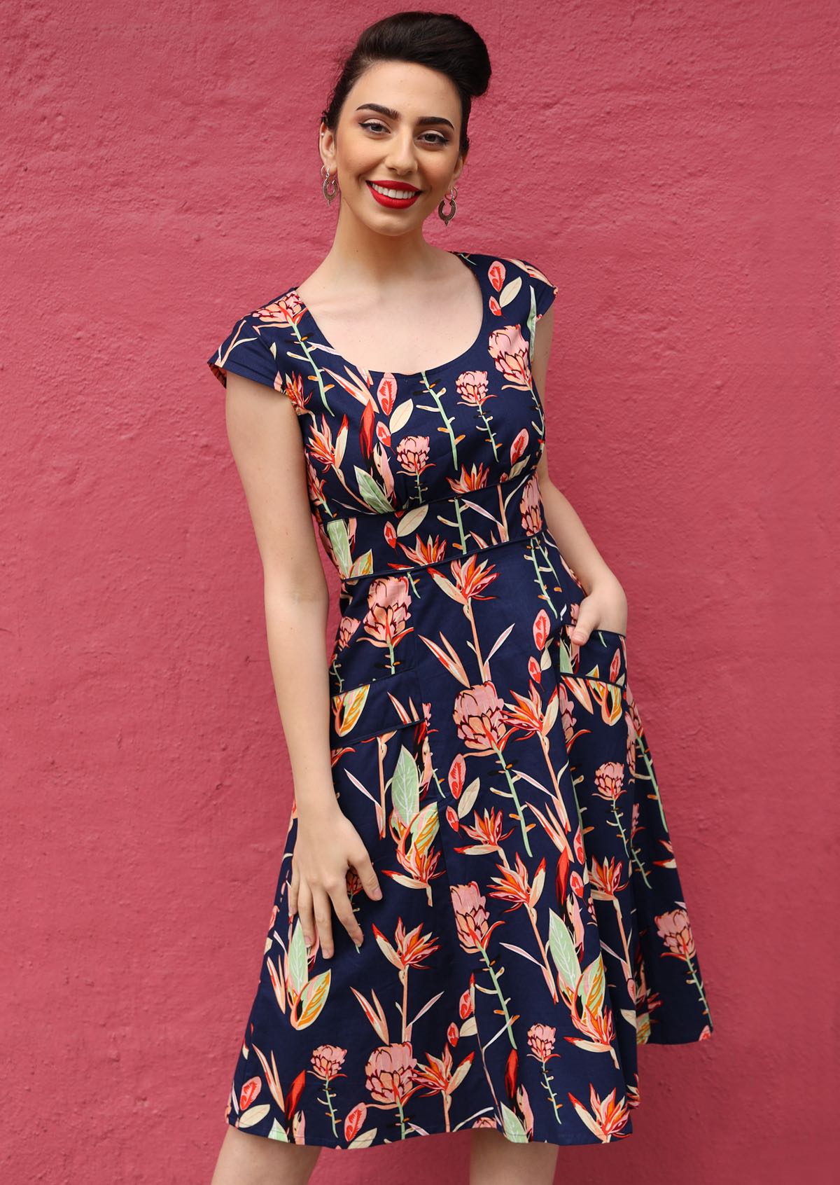1950s Inspired Swing Womens Dress tailored bodice cap sleeve scoop neckline empire waistband flared a-line skirt below the knee length with pockets 100% cotton navy background pink and green toned native floral print | Karma East Australia