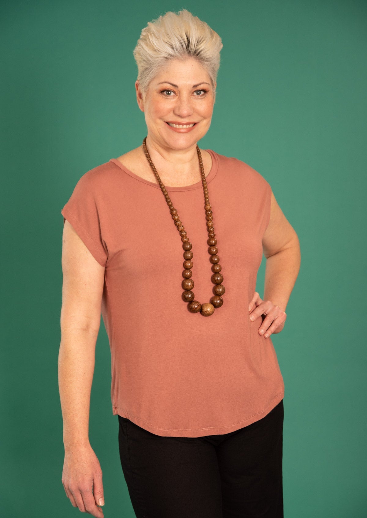 Woman wearing a soft flattering fit dusty pink rayon jersey t-shirt.
