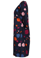 Side view of knee length cotton dress in bold spotty print on navy blue base.
